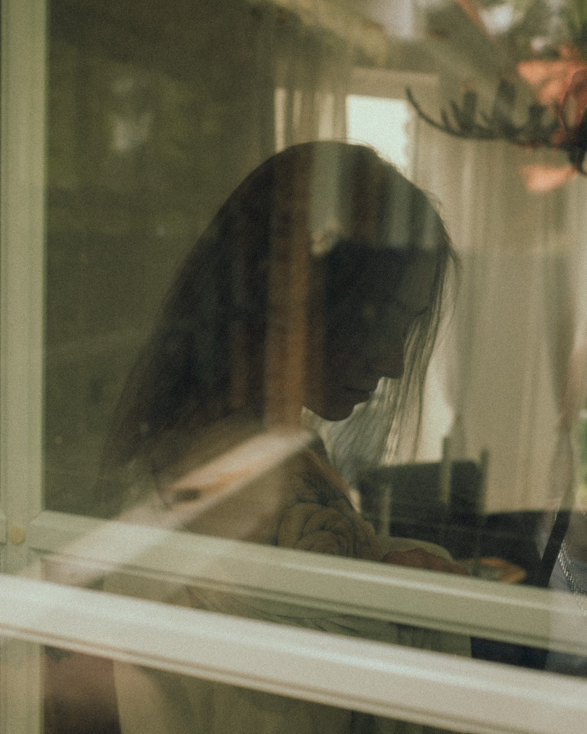 Jana hinter einer Fensterscheibe, Spiegelung im Glas