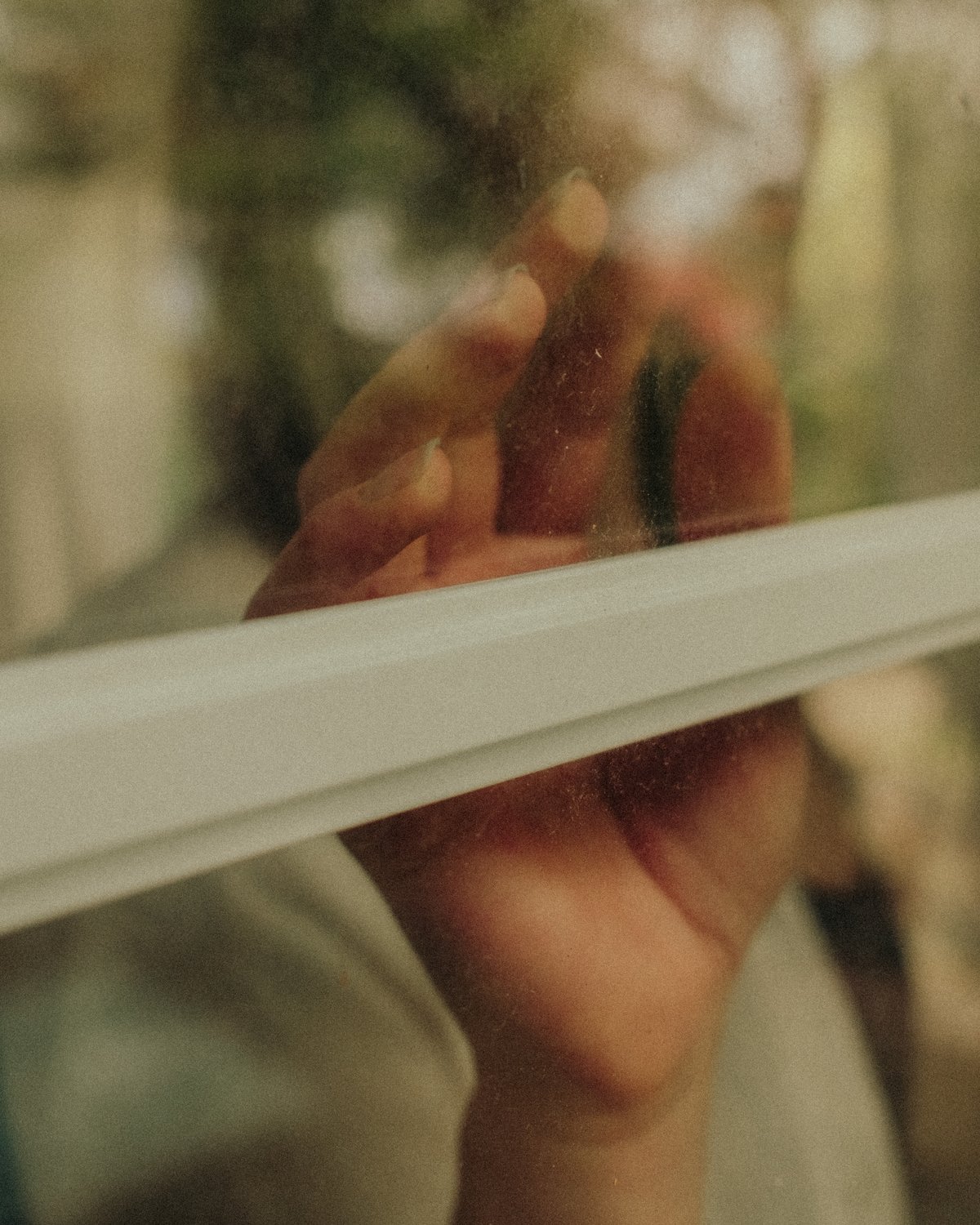 Hand an der Fensterscheibe, Detailaufnahme